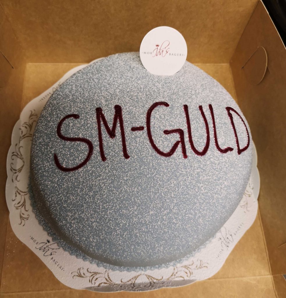 En blå prinsesstårta med texten SM-guld.